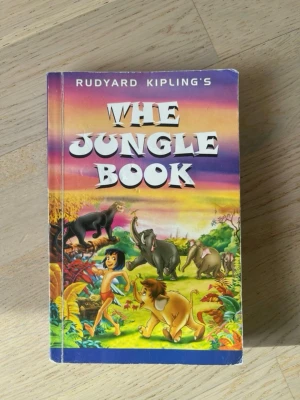 The Jungle Book av Kipling - Färgstark pocketbok med titeln 'The Jungle Book' av Rudyard Kipling. Boken är på engelska och har ett mjukt omslag.