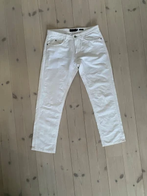 Vita raka jeans från Tiger of Sweden - Säljer ett par vita jeans från Tiger of Sweden med rak passform och klassisk femficksdesign. Jeansen har normal midja och är tillverkade i ett mjukt bomullsmaterial. Perfekta för en clean och stilren look.       Passar dig som är runt 170cm lång 