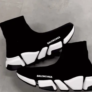 Balenciaga Speed Trainer sneakers - Svarta Balenciaga Speed Trainer sneakers med vit chunky sula och stickad strumpliknande ovandel. Loggan är tryckt i vitt på sidan. Skorna har en futuristisk design och är tillverkade i textil och gummi.