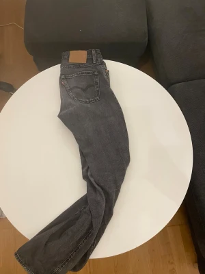 Grå Levi's 501 straight fit jeans - Säljer ett par grå Levi's 501 jeans med klassisk femficksmodell och raka ben. Jeansen har en snygg tvättad look och är tillverkade i slitstark denim. Perfekta för dig som gillar en tidlös och avslappnad stil. Storlek 29/32
