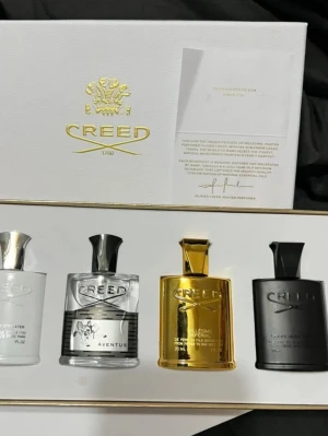 Creed parfymset 4x30ml - Lyxigt parfymset från Creed med fyra flaskor i olika färger: vit, transparent, guld och svart. Flaskorna har exklusiv design med metalliska lock och Creed-logga. Perfekt för dig som vill testa flera ikoniska Creed-dofter i snygg presentförpackning. (Ändads en Intresse koll) 