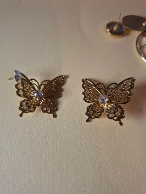 Guldiga fjärilsörhängen med strass - Överge samlingen, utförsäljning till låga priser