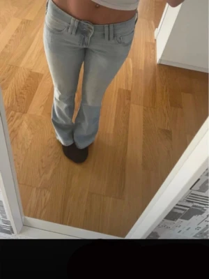 Hollister jeans - Low-rise bootcut jeans från Hollisters, redo att skickas direkt.  🔹 Midja: Low rise 🔹 Modell: Bootcut 🔹 Storlek: W26 / Regular 🔹 Färg: Ljusblå 🔹 Märke: Hollister 🔹 Originalknappar med Hollister-logga Mycket bra skick, använda fåtal gånger – se bilder för detaljer.  Mått: Midja-36cm Innerben-76,5cm Ytterben-98cm Lår-23cm