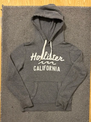 Vintage Hollister Hoodie - Säljer denna feta grå hollister hoodien, sällsynt och svår att få tag på! | Storlek S | Väldigt bra skick| Modell 175cm, 68kg | Hör av vid ytterligare frågor! | Pris diskuterbar vid snabbr köp!