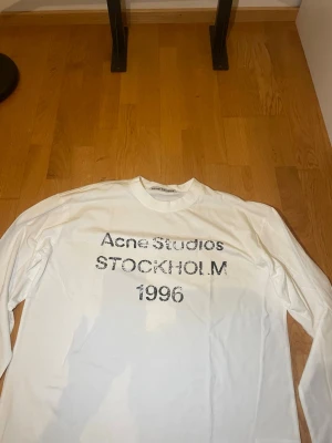 Acne Studios Långärmad T-shirt - En riktigt schysst långärmad T-shirt från märker Acne Studios! Att trycket ser lite slitet ut är design som ni säkert vet. Priset är förhandlingsbart!