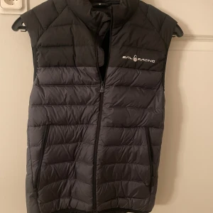 Svart dunväst från Sail Racing - Snygg svart dunväst från Sail Racing i bra skick!