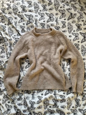 Beige ribbstickad tröja - Säljer en beige ribbstickad tröja med rund hals och långa ärmar.