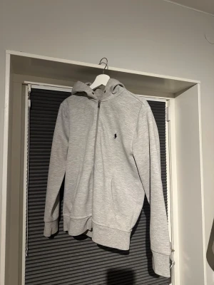 Grå zip hoodie från Polo Ralph Lauren - Grå Ralph lauren zip bra skick men snöret till hoodien saknas. Hör av er vid frågor👍