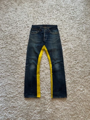 Nudie jeans selvedge regular ralf - Sjuuuuukt feta o unika selvedge jeans från nudie, hade aldrig sålt om de passade mig. Jeansen är i modellen regular Ralf och är straight/bootcut i passformen. De är målade med gult på insidan av benen vilket syns tydligt på bilderna, kanske går att få bort men jag tycker endast att de gör de snyggare. Storlek 29/32! Hela längden: 104 cm Innerben: 80 cm Midja: 38 cm Benöppning: 22 cm