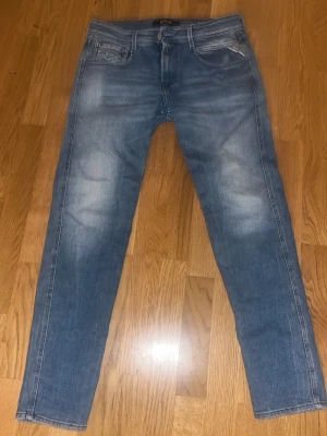Blå raka jeans 28/30 - Säljer ett par klassiska blå jeans med raka ben och snygga slitningar framtill. Jeansen har fem fickor och normal midja. Materialet är denim i bomull och de har en tidlös tvättad look som passar till det mesta. Pris kan diskuteras Anbass slim fit.