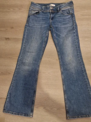 Blå bootcut jeans  - Blå utsvängda jeans från ginatricot storlek 152. Inga fläckar har använt några få gånger men är fortfarande i bra skick. Två fickor på baksidan utan några symboler på. Och Lite lågmidiga  där framme. (Den som vill köpa står också för frakten)     
