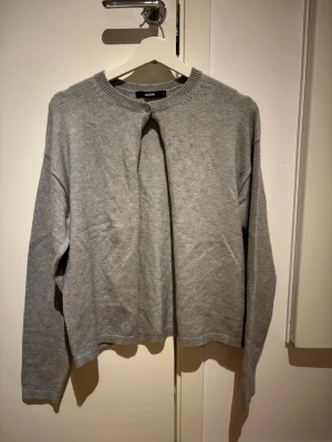 Grå stickad tröja från bikbok  - En enkel och stilren grå stickad tröja från bikbok . Tröjan har rund halsringning, långa ärmar och ribbade muddar vid hals, ärmslut och nederkant. Tillverkad i mjukt material som passar perfekt för lager på lager.