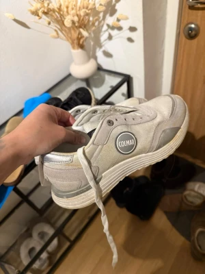 Vita sneakers från Colmar - Snygga vita sneakers från Colmar med rundad tå och vita snören. Skorna har en mix av mocka och textilmaterial samt en vit sula med diskreta detaljer. Colmar-logga på sidan ger en clean och modern look. Defekter finns därav priset 