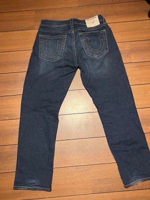 True religion jeans - Ett par mörkblåa jeans ifrån True religion. Bobby-Baggy relaxed i storlek w29. Passar mer som en w32/w33.  Fint skick inte alls använda mycket. Pris kan diskuteras.
