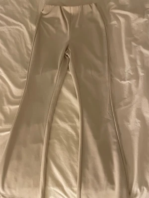 Beige utsvängda leggings - Snygga beige leggings med utsvängda ben och hög midja. Tillverkade i ett stretchigt och mjukt material som sitter skönt på kroppen. Perfekta för dig som gillar en enkel men trendig look.