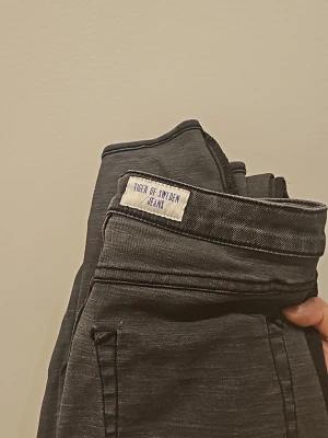 Tiger of Sweden grå jeans  - Snygga grå jeans från Tiger of Sweden med klassisk femficksdesign och raka ben. Jeansen har en diskret tvättad look och är tillverkade i mjukt denimtyg som ger en skön passform. Perfekta för dig som gillar stilrena och tidlösa plagg. Byxan har storlek 29/34"