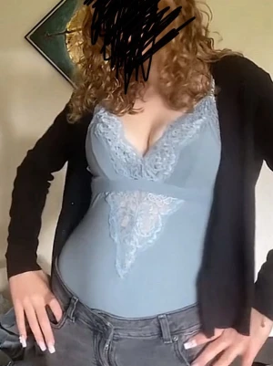  spetsbody med V-ringning - Snygg ljusblå body med spetsdetaljer och djup V-ringning. Bodyn har breda axelband och dekorativ spets framtill som ger en feminin look. Perfekt att styla under en kofta eller kavaj.