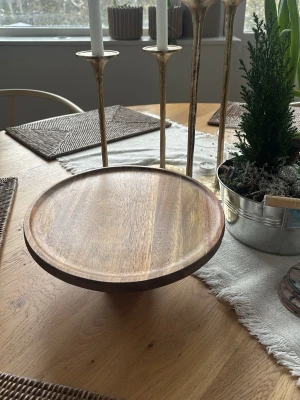 Rund tårtfat i trä på fot - Runt kakfat från Hemtex, nypris ca 700kr. Passar perfekt för servering av kakor, tårta eller frukt! Har en upphöjd kant, och gjord av trä. Perfekt som present till förälder/morförälder. Priset är ej fast!