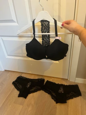 Svart Victorias Secret set som inte längre säljs - Svart Victorias Secret set med spets som innehåller två trosor i storlek s och en bh i storlek 38c med push up💕 Setet är helt nytt med prislapp och säljs inte längre då de köptes för flera år sedan men har aldrig använts och bara legat i en påse. 