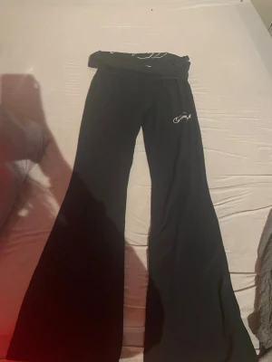 Hoodrich byxor  - Aldrig använda. Säljer ett par svarta mjukisbyxor från hoodrich med utsvängda ben och bred mudd i midjan. Byxorna har vit broderad logga på höften och texten hoodie på midjan. Sköna och perfekta för en chill look.