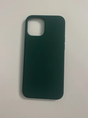 Mörkgrönt mobilskal i silikon iPhone 12 Pro Max - Snyggt mörkgrönt mobilskal i mjukt silikonmaterial som ger ett bra grepp och skyddar mobilen mot repor och stötar. Skalets design är stilren och passar perfekt till dig som gillar en enkel look. Kamerautskärning är anpassad för moderna smartphones.