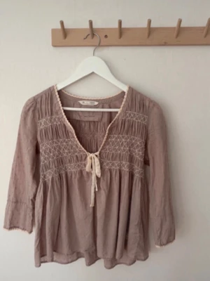 Beige boho-blus med knyt och brodyr - Odd Molly blouse in size 0 (ish XS). Feminine design with the brand’s signature details. Has a slight stain under the arms, but nothing very noticeable when worn. Overall still in good condition. Colour like the first pics  