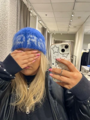 Blå fluffig mössa med vit text - Virkad blå mössa med “Star Girl” text framtill. Handgjord i ull-, mohair- och akrylmix som ger en mjuk och borstad look. Varm och bekväm, passar perfekt till höst och vinter.  Unisex vuxenstorlek.  Material: ull / mohair / akryl Färg: blå  Passar till y2k, streetwear och vardagsstil.  #virkad #handvirkad #mössa #stargirl #unisex #mohair #ullmössa #y2k