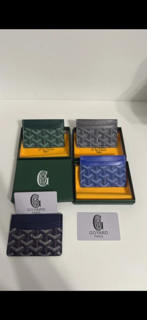Goyard korthållare i flera färger - Snygga korthållare från Goyard i klassiskt mönster. Finns i grönt, grått, blått och mörkblått. Tillverkade i canvas med läderdetaljer och har flera fack för kort. Perfekt accessoar för dig som vill ha något stilrent och exklusivt.