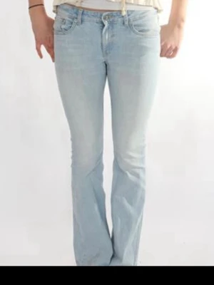 Ljusblå bootcut jeans - Säljer ett par ljusblå bootcut jeans med klassisk femficksdesign och normal midja. Jeansen har en snygg utsvängd passform nedtill och är tillverkade i denim. Perfekta för en avslappnad och trendig look.