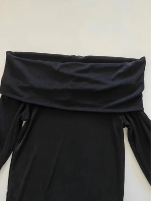 Svart långärmad off shoulder topp - Super fin och skön svart Pieces Off Shoulder Topp inköpt från Vero Moda. Går även att använda som djupkrage som syns på bild 2. Materialet känns skönt mot huden. I nästintill nyskick, inga anmärkningar. Storlek XS. Passar även en S, då materialet är stretchigt.