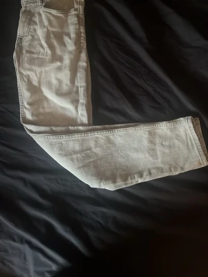 Slim fit gråa - Säljer ett par ljusgrå jeans med rak passform och klassisk femficksdesign. Jeansen har normal midja och är tillverkade i ett mjukt denimtyg som känns bekvämt hela dagen. Perfekta för dig som gillar en clean och enkel stil.