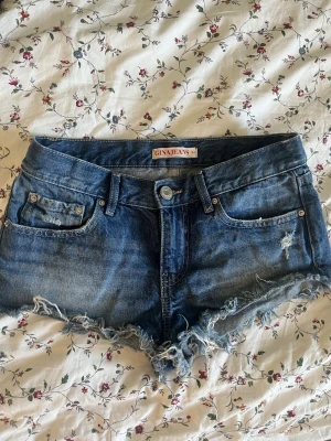 Blå jeansshorts från Gina Jeans - Säljer ett par blå jeansshorts från Gina Jeans med fransig kant och slitna detaljer. 