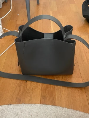 Handväska - Super snygg handväska köpt ifrån Gina tricot. Den är mörkgrön i färg med ser mer svart ut. Inga defekter