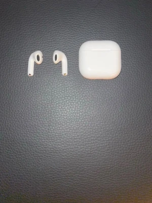 Apple Airpods 4 ANC med faktura  - Säljer ett par trådlösa vita in-ear hörlurar med laddningsetui. Hörlurarna har en stilren och kompakt design i plast och passar perfekt för musik, poddar och samtal på språng. Laddningsetuiet är också vitt och har en smidig magnetisk stängning.