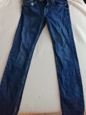 Mörkblå skinny jeans - Säljer ett par mörkblå skinny jeans med klassisk femficksdesign och normal midja. Jeansen har smal passform hela vägen ner och är tillverkade i ett stretchigt denimtyg för extra komfort. Perfekta till en avslappnad och trendig look.