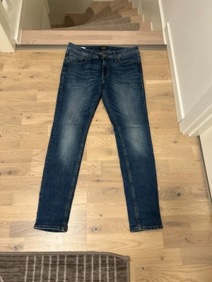 Mörkblå slim fit jeans - Snygga mörkblå slim fit jeans med klassisk femficksdesign och lätt slitna detaljer på låren. Jeansen har normal midja och raka ben. Tillverkade i ett mjukt denimtyg som ger en bekväm känsla och passar till många olika stilar.