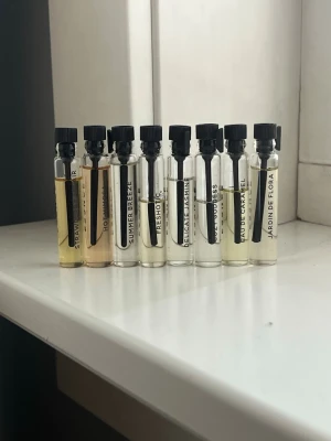 Set med 8 parfymprover i glasflaskor - Säljer ett set med 8 parfymprover i små genomskinliga glasflaskor med svarta skruvkorkar. Doftnamn som Summer Breeze, Delicate Jasmine och Eau de Caramel syns på etiketterna. Perfekt för dig som vill testa olika dofter innan du bestämmer dig. Orginalpis är 45kr/st.