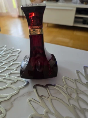 BeyoncéHeatEau de - Snygg parfymflaska i mörkrött glas med elegant, skulptural form och guldfärgad ring runt halsen. Flaskan har en modern och lyxig design som sticker ut på sminkbordet. Perfekt för dig som gillar unika och stilrena accessoarer.Beyoncé Heat Eau de Parfum för Kvinnor