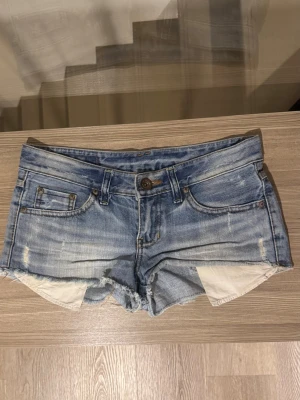 Lågmidjade jeansshorts  - Lågmidjade jeansshorts från märket Gee Code i bra skick. Storlek S enligt lappen (se bild 4), bär ej själv S så kan tyvärr inte testa storlek. 