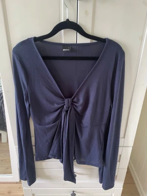 Mörkblå knytt tröja från Gina Tricot - Snygg mörkblå knytt topp från Gina Tricot med lång ärm och knyt framtill. Tröjan är i storlek L. Är i mycket fint skick o nästan aldrig använd.