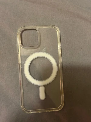 Transparent MagSafe-kompatibelt mobilskal  - iPhone 15 skal Snyggt genomskinligt mobilskal med MagSafe-kompatibilitet. Skalets design är stilren med en tydlig cirkel och markering för MagSafe på baksidan. Tillverkat i tålig plast som skyddar mobilen utan att dölja dess originalfärg.