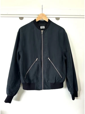 Weekday - grå blå bomber jacka - storlek XS / S - Stilren mörkblå / grå bomberjacka från Weekday i storlek XS för herr, S för dam. Populära modellen Monoc Bomb Jacket med dragkedja framtill och två snedställda fickor med dragkedja. Muddar finns vid kragen, ärmsluten och nederkanten. Finvävt ”pudrigt” yttertyg i 70% modal, så bra material som andas. Tidlös klassiker som passar till allt! Fint skick!