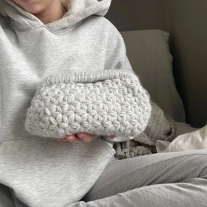 Ljusgrå stickad kuvertväska - En grå virkad clutch bag❣️100% ull. Ramen är 22cm lång. Material kostnad: 290kr. 14h arbete. Skriv vid fler frågor eller om ni vill göra en special beställning❣️