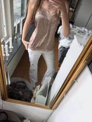 Champagne rosa leopardmönstrad linnetopp💗 - Säljer en champagne rosa linnetopp med leopardmönster och spetsdetaljer vid halsringning och nederkant. Toppen är ärmlös och har tunna axelband, perfekt för en trendig och avslappnad look. Materialet är glansigt och mjukt💗