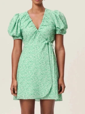 Grön omlottklänning från Adoore - Söt grön omlottklänning från Adoore med vita småblommiga detaljer. Klänningen har puffiga korta ärmar, v-ringning och knyts i midjan. Oanvänd med prislapp kvar.