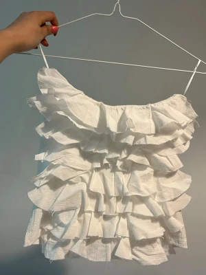 Vit volangtop från Zara - Säljer en vit topp från Zara med flera lager av volanger som passar för studenten och sommaren!!💓det är lätt material som känns luftigt och fräscht. Skriv privat för mått och bilder!