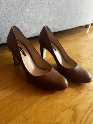 Bruna klackskor  - Bruna klackskor från Belmondo, nypris 1199kr. Använda några gånger men inga defekter annat än sliten sula.