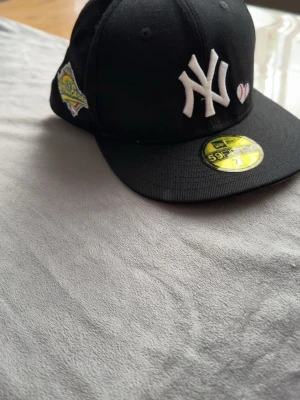 New era keps  - Jag säljer min new era keps för den är för liten på mig och har haft den typ 3/4 dagar. Den är svart/ ish mörk blå och har två märken på. En på sidan och en där bak