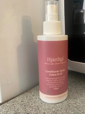 Hjärtligt Conditioner Spray UV - Balsamspray från Hjärtligt med UV-skydd och färgbevarande egenskaper. Innehåller vitaminer, aminosyror, växtmineraler, rapsolja och arganolja. Kommer i en vit plastflaska med rosa etikett och sprayfunktion. Svensktillverkad, 150 ml.