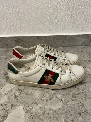 Gucci Ace vita sneakers med bi - Gucci Ace Bee || Storlek 44 (UK 9,5) Inermåttet är 28,5cm || Skorna är i okej skick, slitage förekommer (se bilder) || Mitt pris 1499kr || Tveka inte på att höra av dig vid frågor eller funderingar 